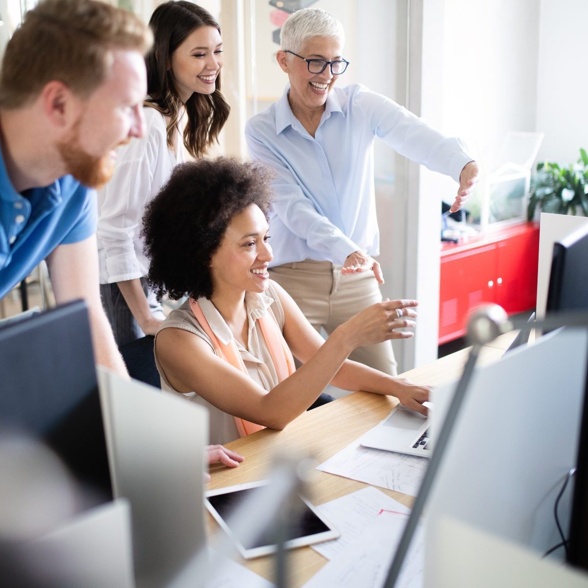 AdobeStock_286299430 office support Diverse group of colleagues collaborating on one desktop computer